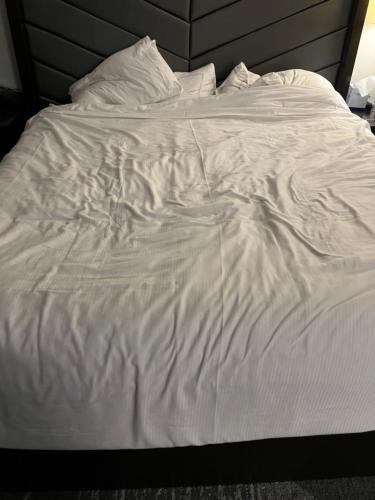 un letto non preparato con lenzuola e cuscini bianchi di Family Vacation North a Sacramento