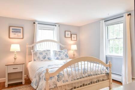 ein Schlafzimmer mit einem Bett, zwei Fenstern und zwei Lampen in der Unterkunft A C 3 Min Walk to Beach on Long Pond in Yarmouth