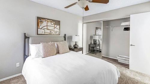 1 dormitorio con cama blanca y ventilador de techo en Landing Modern Apartment with Amazing Amenities (ID1214X776) en Las Vegas