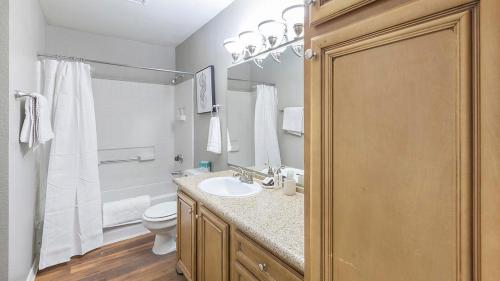 Baño blanco con lavabo y aseo en Landing Modern Apartment with Amazing Amenities (ID1214X776) en Las Vegas