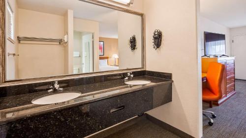 baño con 2 lavabos y espejo grande en Best Western Golden Key, en Auburn
