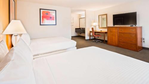 een hotelkamer met 2 bedden en een bureau bij Best Western Golden Key in Auburn