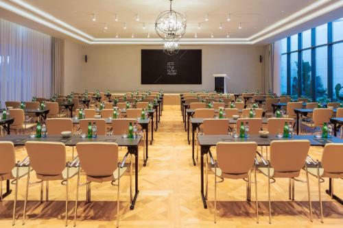a conference room with tables and chairs and a screen at EVOLUTION Cascais-Estoril Hotel in Estoril