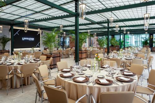 a banquet hall with tables and chairs and a screen at EVOLUTION Cascais-Estoril Hotel in Estoril