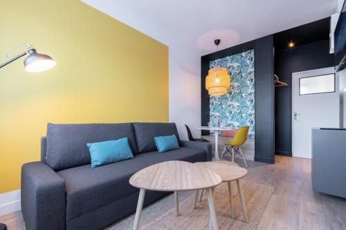 a living room with a couch and a table at Marcq-en-Baroeul - Beautiful apartment Art-déco ! in Marquette-lès-Lille