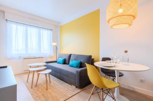 a living room with a couch and a table at Marcq-en-Baroeul - Beautiful apartment Art-déco ! in Marquette-lès-Lille