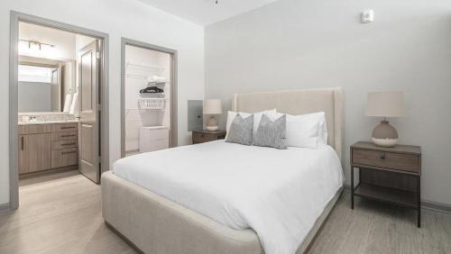 a white bedroom with a large bed and a bathroom at Landing Modern Apartment with Amazing Amenities (ID1208X247) in Charlotte