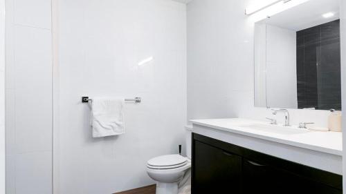 uma casa de banho branca com um WC e um lavatório em Landing Modern Apartment with Amazing Amenities (ID8429X99) em Baltimore
