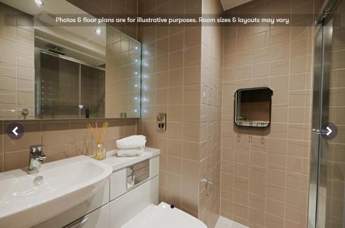 y baño con lavabo y ducha con espejo. en Fully equipped modern studios in Glasgow West End for Students Only, en Glasgow