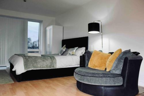 a bedroom with a bed and a chair and a lamp at Modern City Central Studio APT in Birmingham