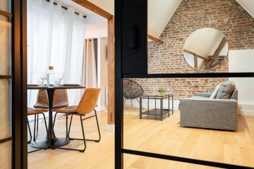 - un salon avec un mur en briques, une table et des chaises dans l'établissement Old Lille - Lovely typical apartment!, à Lille