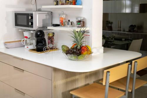 a kitchen counter with a bowl of vegetables on it at Villa L'Artist en bord de mer avec piscine privée in Sainte-Rose