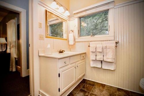 La salle de bains est pourvue d'un lavabo, d'une fenêtre et de serviettes. dans l'établissement College of Wooster 3100 sq ft. Historic Home, à Wooster