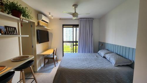 a bedroom with a bed and a desk and a desk at Flat confortável próximo a praia! in Rio de Janeiro