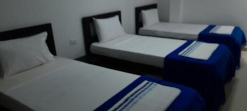 two twin beds in a room with at Hotel La Guajira - Centro Historico in Ríohacha