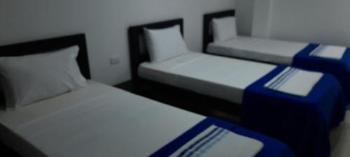 two twin beds in a room with at Hotel La Guajira - Centro Historico in Ríohacha