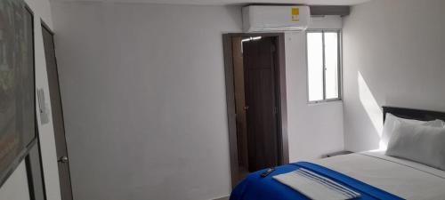 a bedroom with a bed and a window and a door at Hotel La Guajira - Centro Historico in Ríohacha