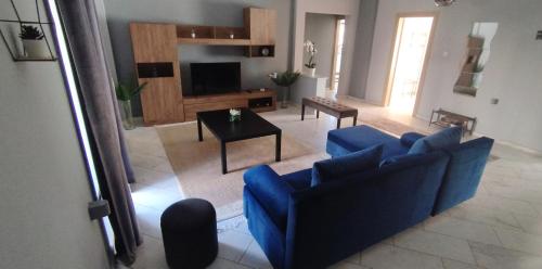 ein Wohnzimmer mit einem blauen Sofa und einem Tisch in der Unterkunft Meteora House with a view in Kalambaka