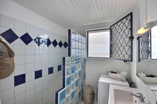 a bathroom with blue and white tiles and a sink at Villa Alma Da Lua in Saint-Pierre