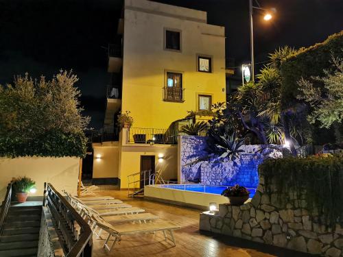 a house at night with a building in the background at L'Ulivo Resort in Vico Equense