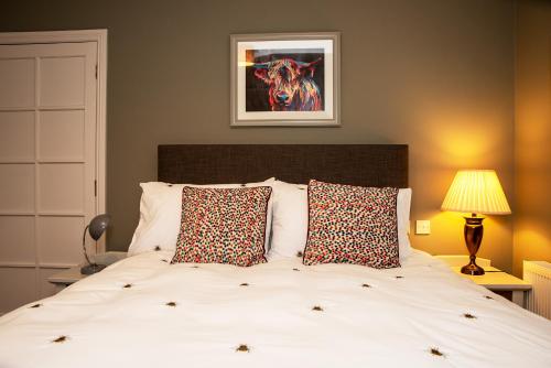 een slaapkamer met een groot wit bed met 2 kussens bij The Veterinary @ Kildare Village in Kildare