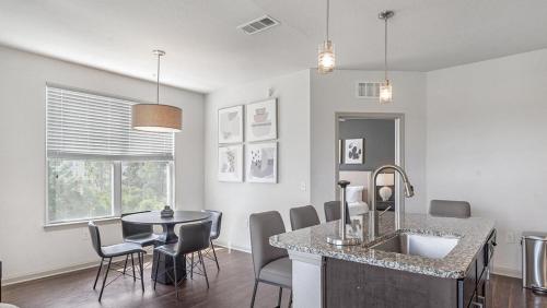 uma cozinha com um lavatório e uma mesa com cadeiras em Landing Modern Apartment with Amazing Amenities (ID9574X29) em Middleburg