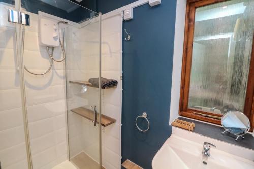 een badkamer met een glazen douche en een wastafel bij Studio 1 in Totnes