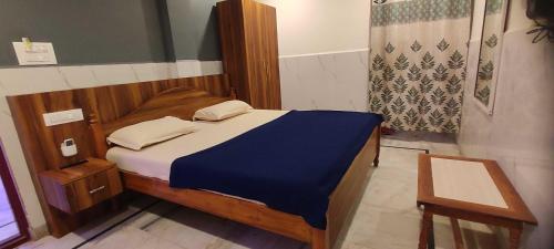 een kleine slaapkamer met een bed met een blauwe deken bij OYO 82374 Hanuman Residence in Erragondapālem