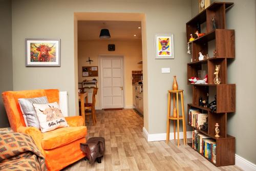 a living room with a chair and a book shelf at The Veterinary @ Kildare Village in Kildare