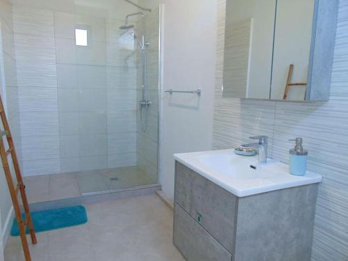 ein Bad mit einem Waschbecken und einer Dusche in der Unterkunft Spacious 3-Bedroom Apartment near Pereybere Beach in Pereybere