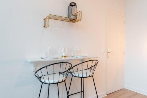 - une petite table blanche avec deux chaises dans la chambre dans l'établissement Lille Cormontaigne - Nice studio, à Lille