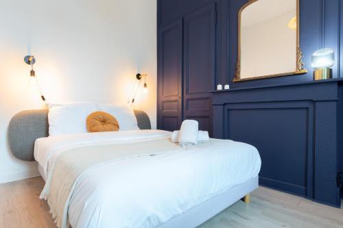 une chambre avec un grand lit et un miroir dans l'établissement Lille Cormontaigne - Nice studio, à Lille