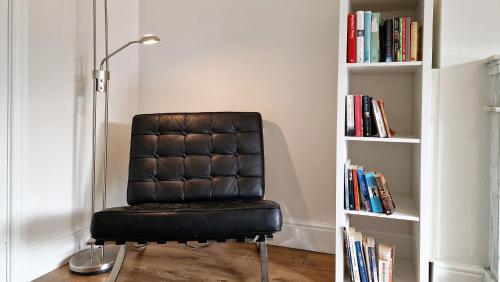a black chair sitting next to a book shelf at 2 minute walk to LUAS (tram) in Dublin