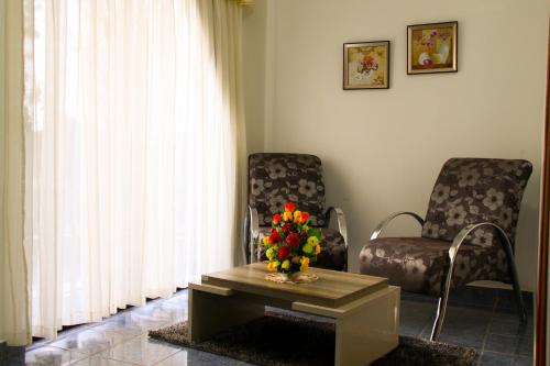a living room with two chairs and a table with flowers at Müller Hotel in Bella Vista