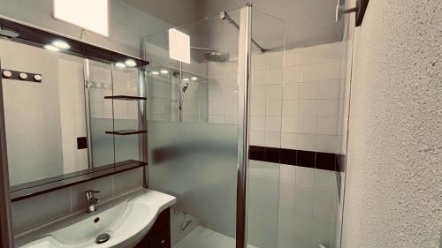 une salle de bain avec une douche en verre et un lavabo dans l'établissement Maison des dunes, à 100m de la mer, à Saint-Hilaire-de-Riez