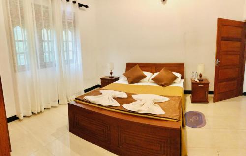 ein Schlafzimmer mit einem großen Bett mit Handtüchern darauf in der Unterkunft tashivilla in Maggona West
