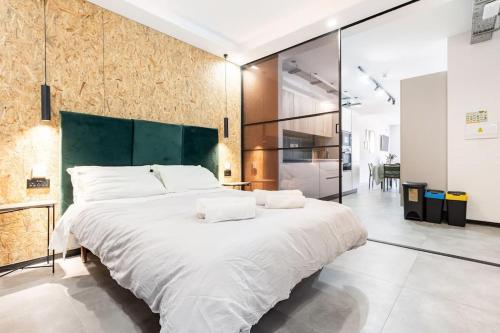 un grande letto bianco in una stanza con pareti di vetro di Stay-Sliema centrally located retro one bedroom a Sliema