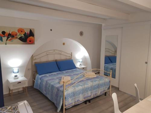 a bedroom with a large bed with blue pillows at Rosso Moro in Ragusa