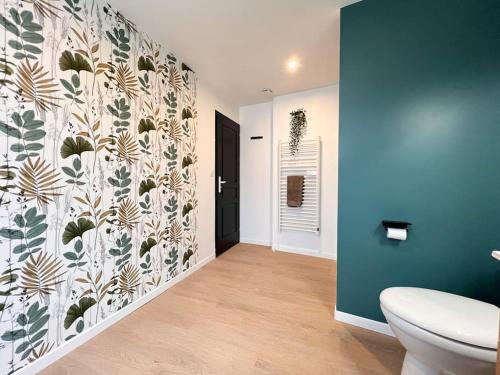 ein Bad mit einem WC und einer Wand in der Unterkunft LA FEUILLERAIE N2-Standingappart-Wifi-Proche ville in Fontenay-le-Comte