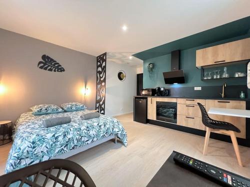 ein Schlafzimmer mit einem Bett, einem Fernseher und einem Tisch in der Unterkunft LA FEUILLERAIE N2-Standingappart-Wifi-Proche ville in Fontenay-le-Comte