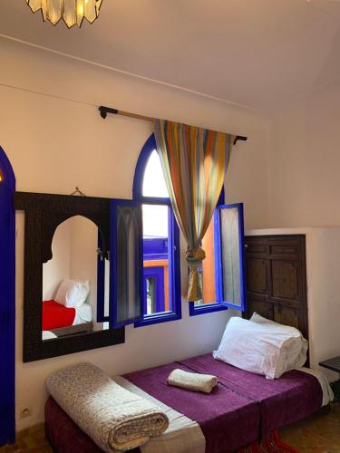 sypialnia z łóżkiem i dużym lustrem w obiekcie Hotel Dar El Qdima w mieście As-Suwajra