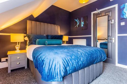 a bedroom with a large bed with a blue blanket at Room 08 - Sandhaven Rooms Double in South Shields