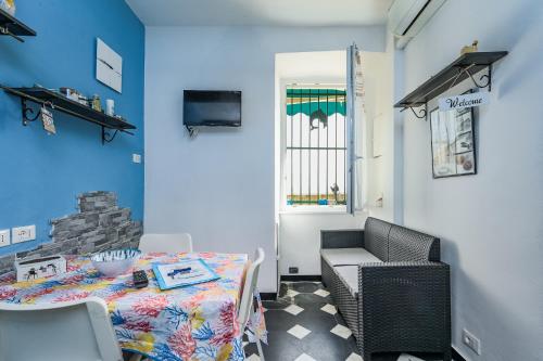 a dining room with a table and a blue wall at IL RIFUGIO SUL MARE - GenovaInRelax in Genova
