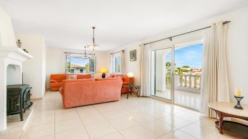 a living room with an orange couch and a balcony at Villa Alma de Mar - Exceptional Villa with Marina Views & Pool in Port d'Addaia
