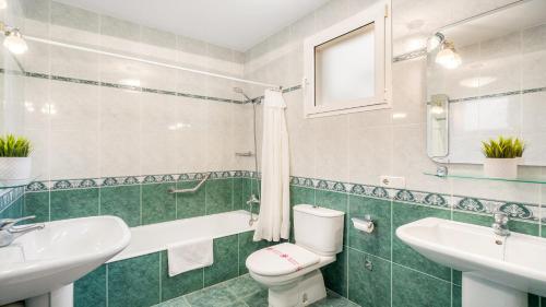 a bathroom with a white toilet and a sink at Villa Alma de Mar - Exceptional Villa with Marina Views & Pool in Port d'Addaia