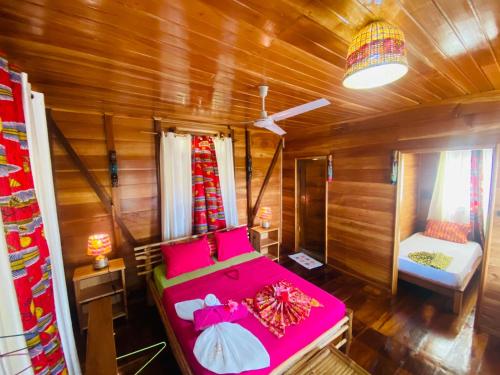 a bedroom with a bed in a wooden room at Monte Mar SãoTomé in M. Peixe