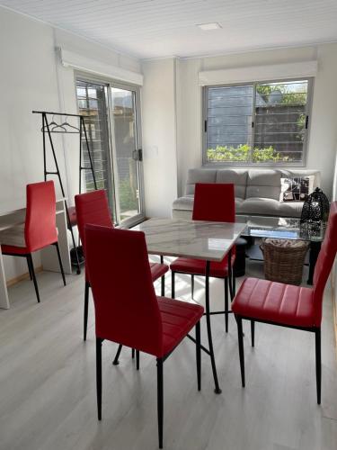 a living room with a table and red chairs at Las Marinas in Balneario Buenos Aires