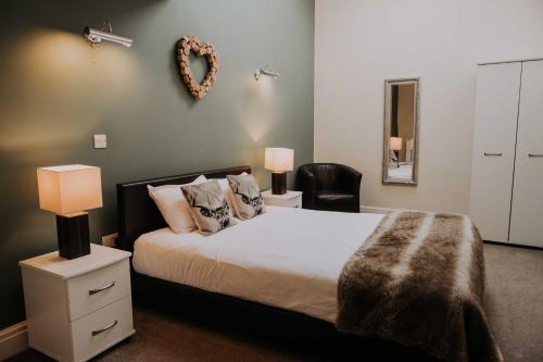 a bedroom with a bed and a chair at Pattys Barn Holiday Cottages, Cabins and Venue Hire in Cockerham