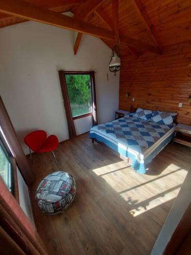 a bedroom with a bed and a wooden floor at El paraíso de Quillon in Quillón