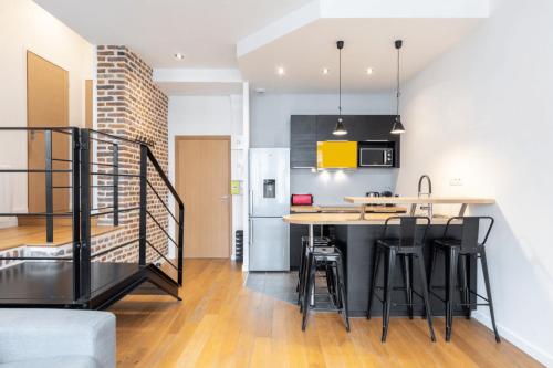 une cuisine et un salon avec une table et des chaises dans l'établissement Grand' Place - Beautiful apartment for 2, à Lille